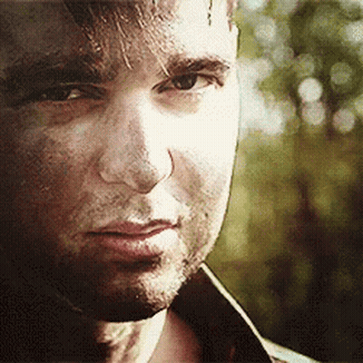A Close Up Of A Man 'S Face With A Slight Smile On His Face . GIF