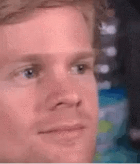 A Close Up Of A Man 'S Face With A Slight Smile On His Face . GIF