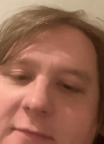 A Close Up Of A Man 'S Face With A Slight Smile On His Face GIF