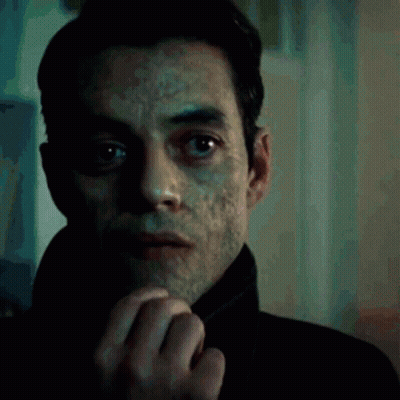 A Close Up Of A Man 'S Face With A Slight Smirk On His Face GIF