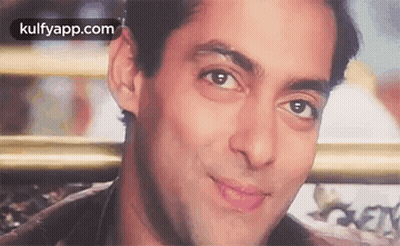 A Close Up Of A Man 'S Face With A Smile On His Face And A Blurred Background . GIF