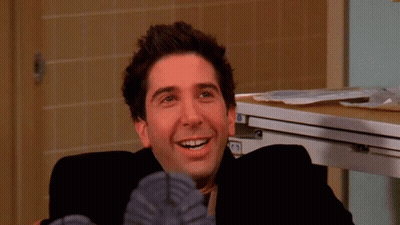 A Close Up Of A Man 'S Face With A Smile On His Face And His Feet Up GIF
