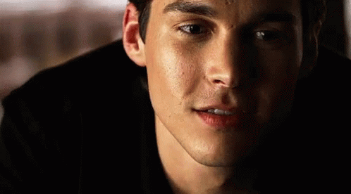 A Close Up Of A Man 'S Face With A Smile On His Face In The Dark . GIF