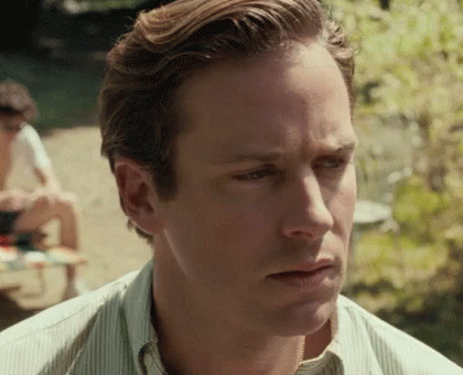 A Close Up Of A Man 'S Face With A Striped Shirt And A Serious Look On His Face . GIF