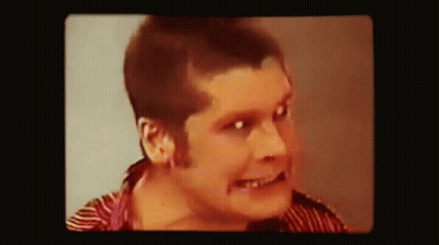 A Close Up Of A Man 'S Face With A Striped Shirt On . GIF