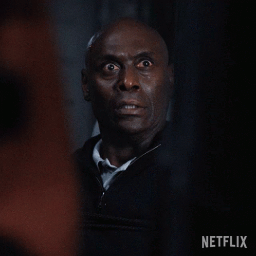 A Close Up Of A Man 'S Face With A Surprised Look On His Face In A Dark Room . GIF