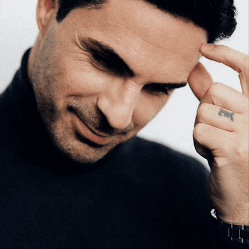 A Close Up Of A Man 'S Face With A Tattoo On His Left Hand GIF