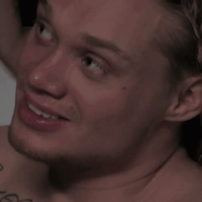 A Close Up Of A Man 'S Face With A Tattoo On His Shoulder GIF
