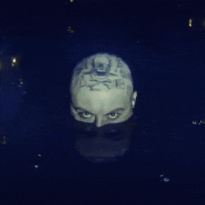 A Close Up Of A Man 'S Face With A Tattoo On It GIF