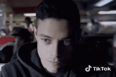 A Close Up Of A Man 'S Face With A Tiktok Logo In The Background GIF