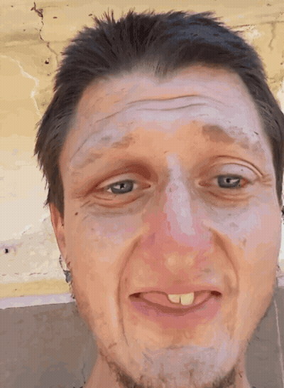 A Close Up Of A Man 'S Face With A Tongue Sticking Out GIF