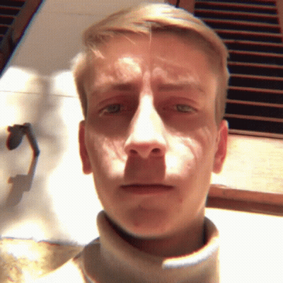 A Close Up Of A Man 'S Face With A Turtleneck Sweater GIF