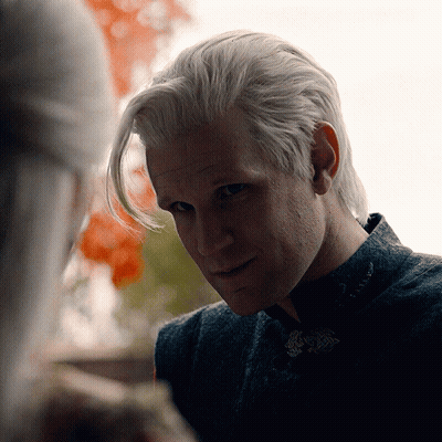 A Close Up Of A Man 'S Face With A Woman Behind Him GIF