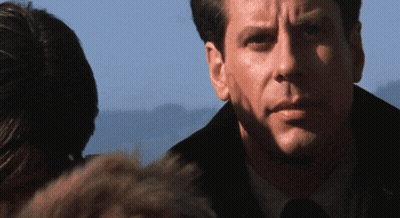 A Close Up Of A Man 'S Face With A Woman Behind Him GIF