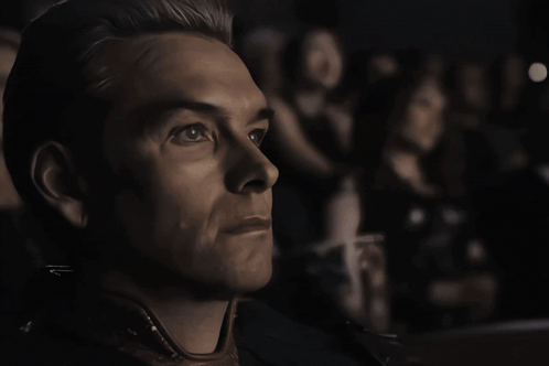 A Close Up Of A Man 'S Face With A Woman In The Background GIF