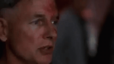 A Close Up Of A Man 'S Face With Blood On It And A Blurry Background . GIF