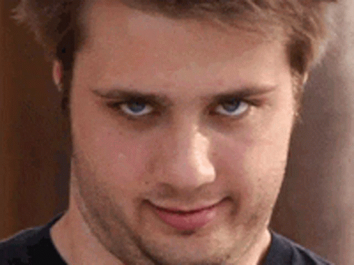 A Close Up Of A Man 'S Face With Blue Eyes And A Beard . GIF
