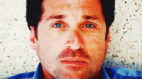 A Close Up Of A Man 'S Face With Blue Eyes And A Beard GIF