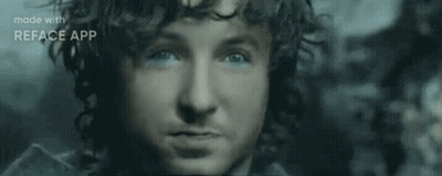 A Close Up Of A Man 'S Face With Blue Eyes And A Beard . GIF
