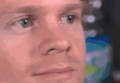 A Close Up Of A Man 'S Face With Blue Eyes And A Blurred Background . GIF