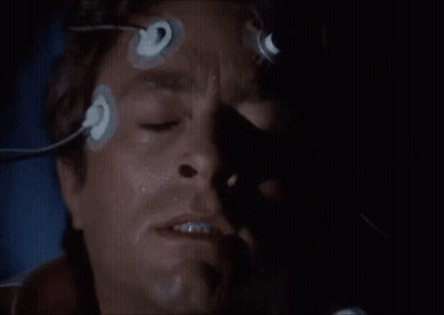 A Close Up Of A Man 'S Face With Blue Eyes And A Shadow On His Face . GIF