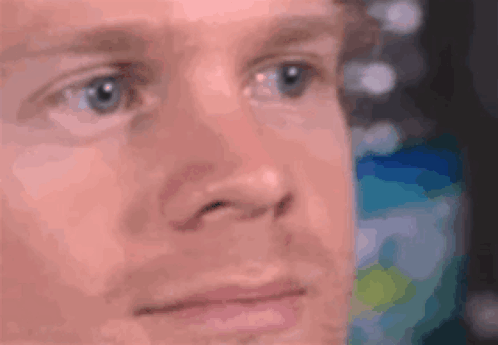 A Close Up Of A Man 'S Face With Blue Eyes Looking At Something . GIF