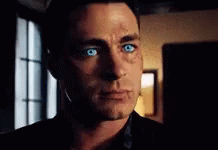 A Close Up Of A Man 'S Face With Blue Eyes Looking At The Camera . GIF