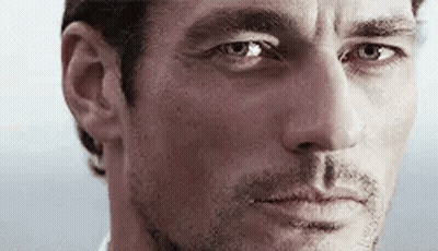 A Close Up Of A Man 'S Face With Blue Eyes Looking At The Camera . GIF