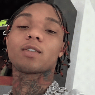 A Close Up Of A Man 'S Face With Dreadlocks And A Tattoo On His Neck GIF