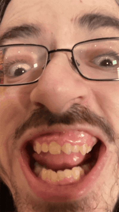 A Close Up Of A Man 'S Face With Glasses And A Mustache GIF