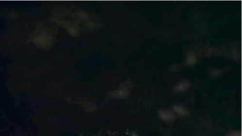 A Close Up Of A Man 'S Face With Glowing Eyes And A Red Jacket . GIF