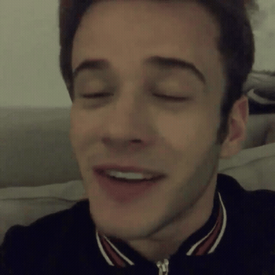 A Close Up Of A Man 'S Face With His Eyes Closed And A Smile On His Face GIF