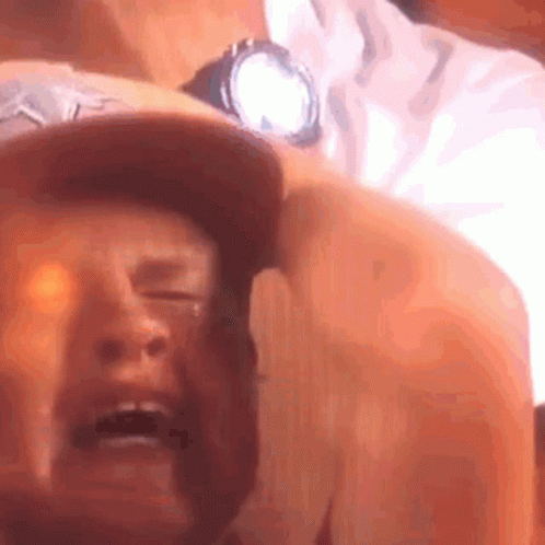 A Close Up Of A Man 'S Face With His Eyes Closed And A Watch On His Wrist . GIF
