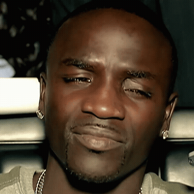 A Close Up Of A Man 'S Face With His Eyes Closed And Earrings On GIF