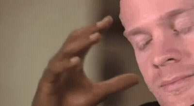 A Close Up Of A Man 'S Face With His Eyes Closed And His Hand On His Head . GIF