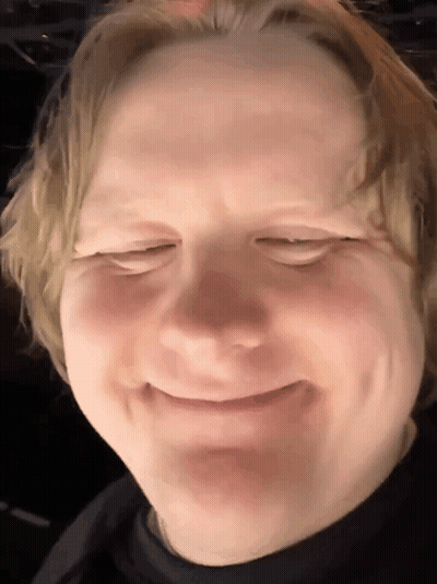 A Close Up Of A Man 'S Face With His Eyes Closed And Smiling GIF