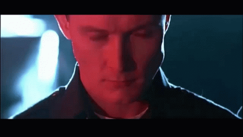 A Close Up Of A Man 'S Face With His Eyes Closed In A Dark Room GIF