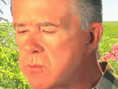 A Close Up Of A Man 'S Face With His Eyes Closed In A Field GIF