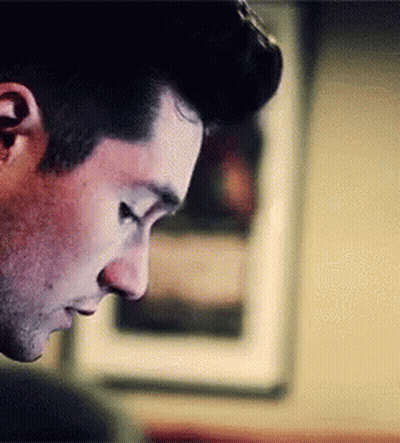 A Close Up Of A Man 'S Face With His Eyes Closed Looking Down . GIF