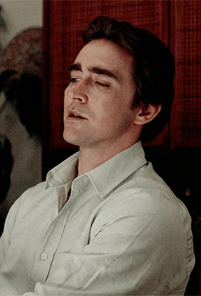A Close Up Of A Man 'S Face With His Eyes Closed Wearing A White Shirt GIF