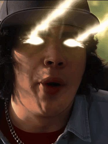 A Close Up Of A Man 'S Face With His Eyes Glowing GIF
