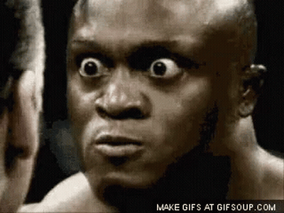 A Close Up Of A Man 'S Face With His Eyes Wide Open Looking At Another Man . GIF