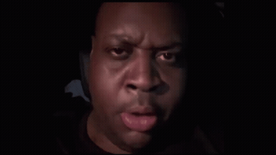 A Close Up Of A Man 'S Face With His Finger On His Mouth . GIF