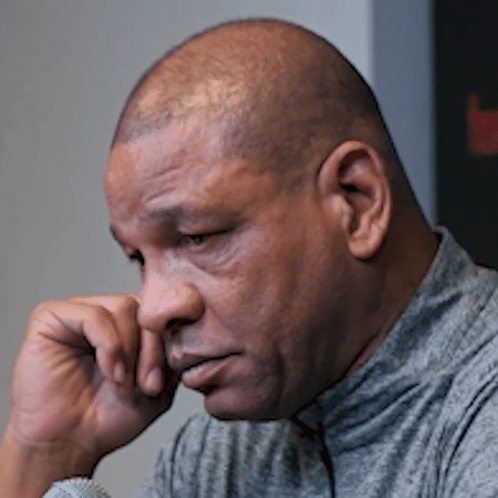 A Close Up Of A Man 'S Face With His Hand Resting On His Chin GIF