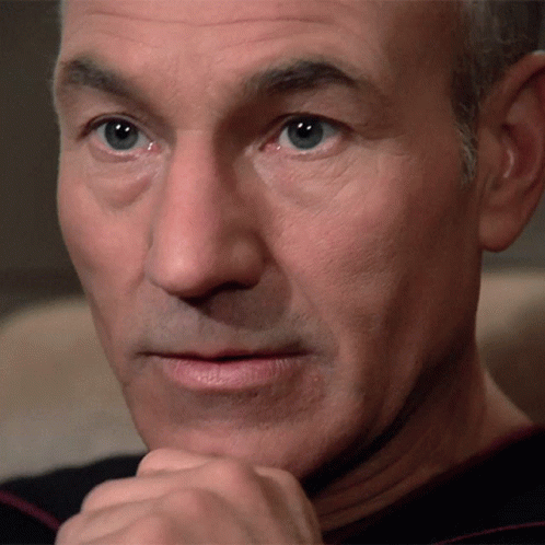 A Close Up Of A Man 'S Face With His Hand Under His Chin GIF