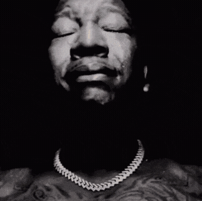 A Close Up Of A Man 'S Face With His Hands Folded In Prayer GIF