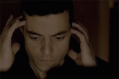 A Close Up Of A Man 'S Face With His Hands On His Head .. GIF