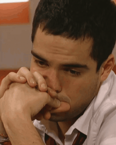 A Close Up Of A Man 'S Face With His Hands On His Mouth GIF