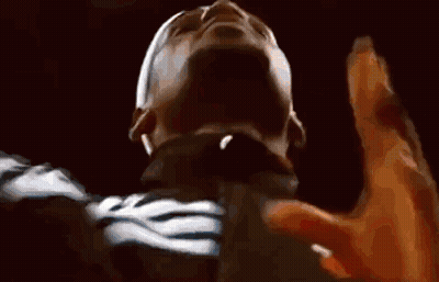 A Close Up Of A Man 'S Face With His Hands Up In The Air . GIF