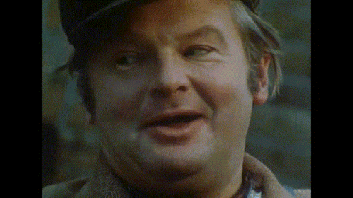 A Close Up Of A Man 'S Face With His Mouth Open And A Hat On GIF